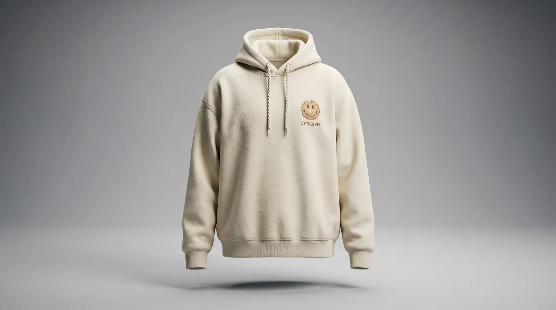 The CR3ASED homepage as its opening animation settles: a bone-coloured heavyweight hoodie, smoothed flat, filling a soft grey frame.