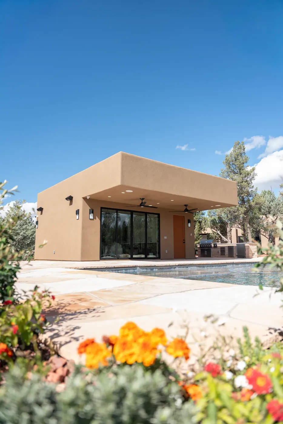 A single-story desert home behind flowering planting.