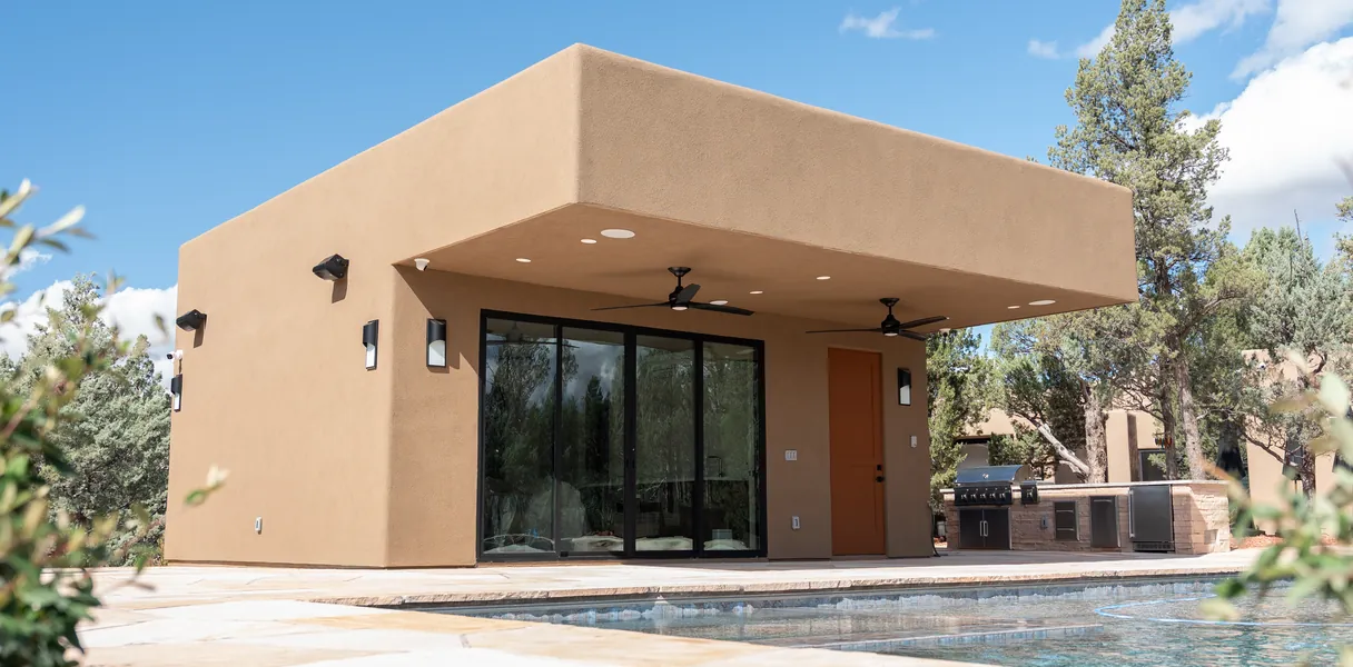 A single-storey desert home behind flowering planting.