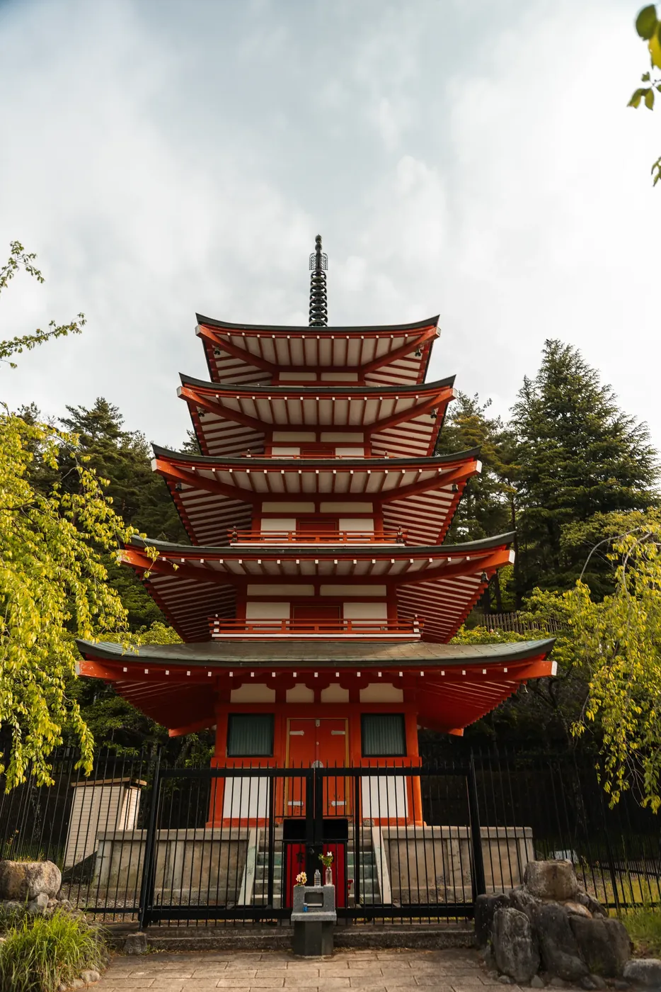 A red five-story pagoda among trees.