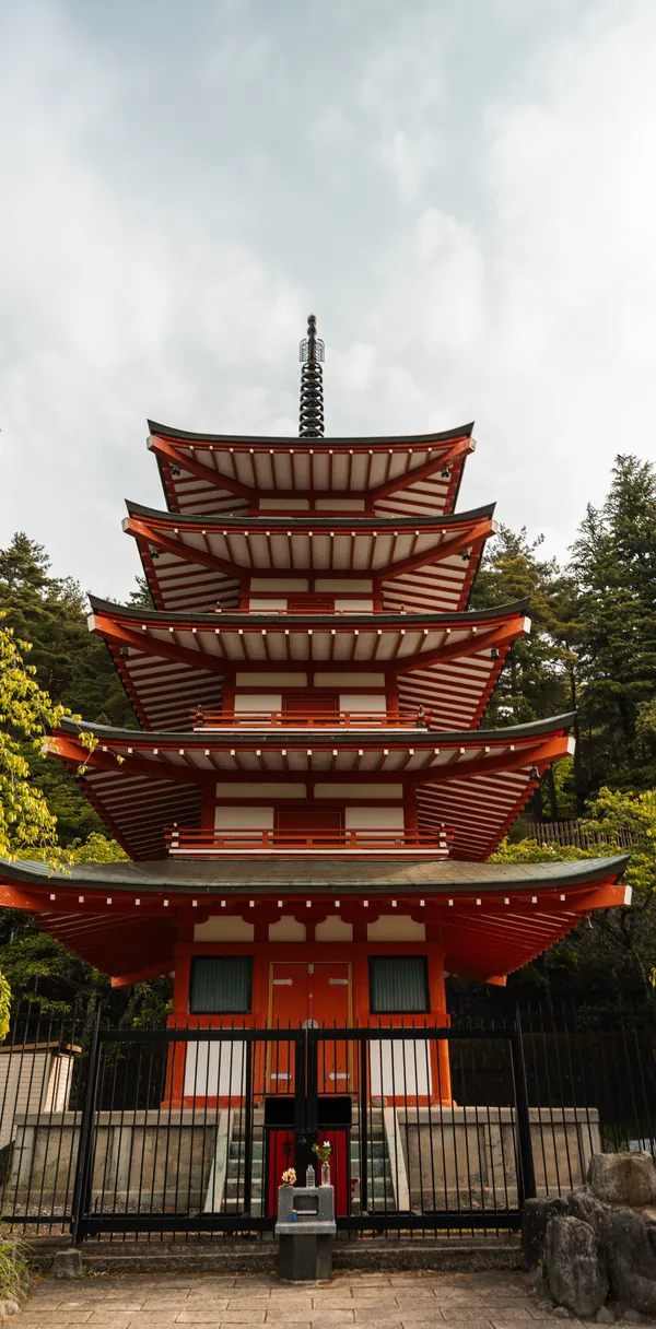 A red five-storey pagoda among trees.