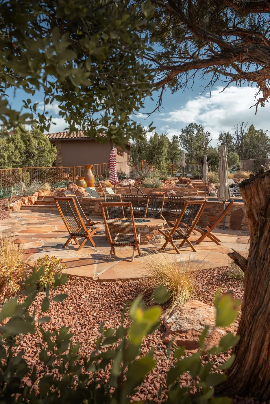 An outdoor dining terrace with a fire pit and desert planting.