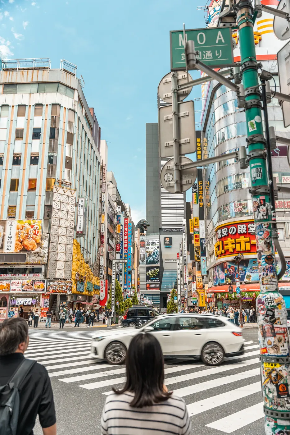 A Tokyo crossing beneath stacked neon signage.